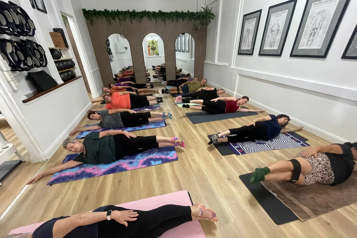 A group of people doing a Pilates exercise
